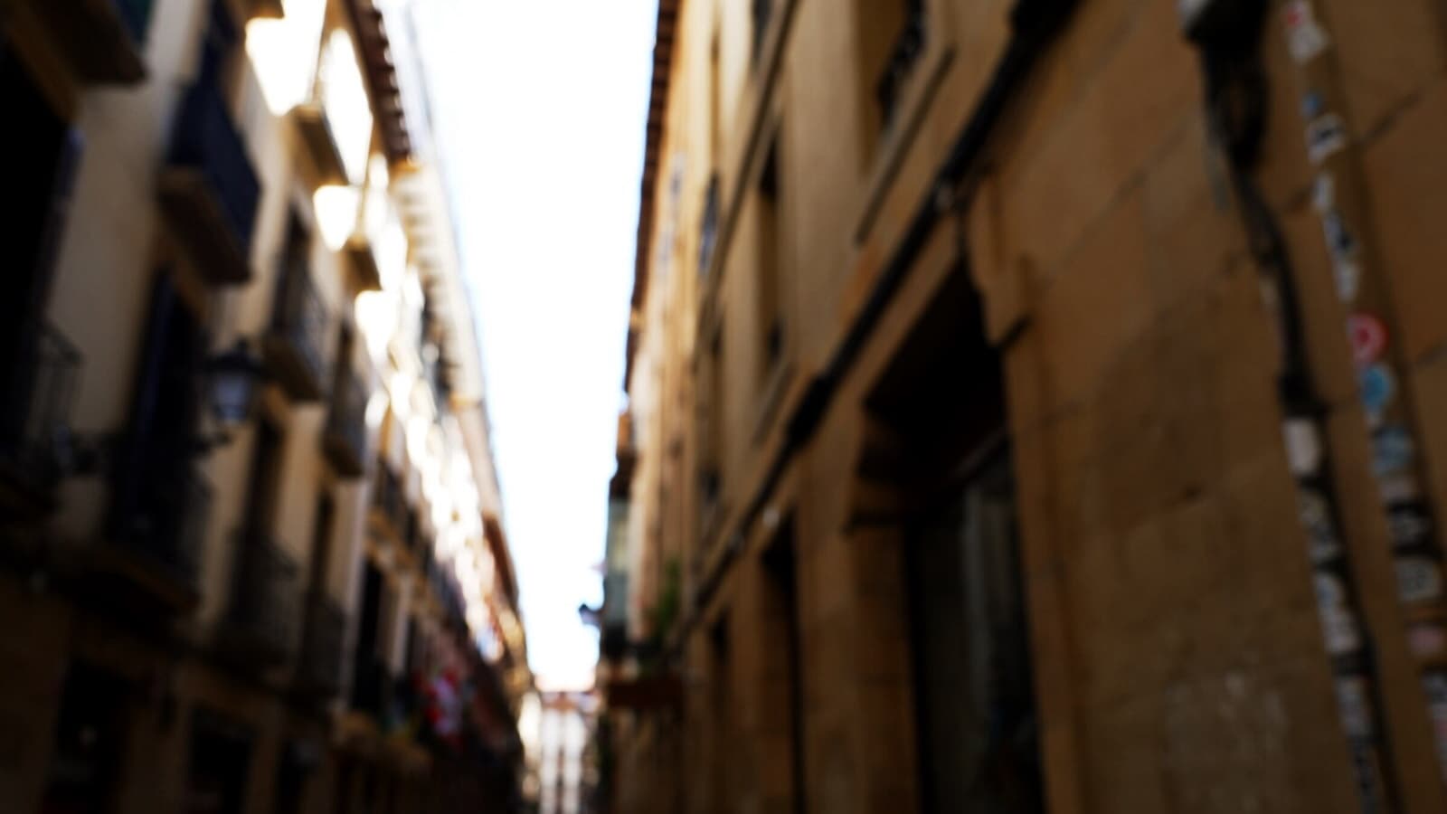 旧市街の路地。夕方、バルの灯りが順番に点いていく